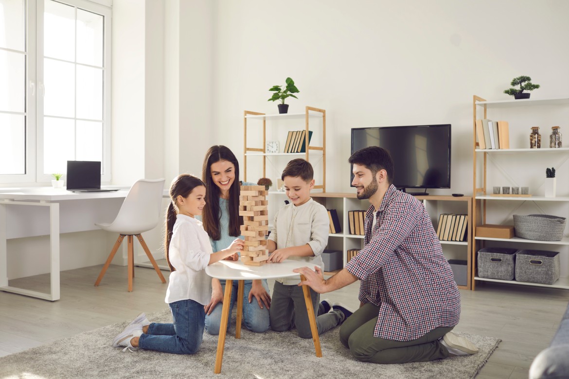 Happy family with kids playing board games