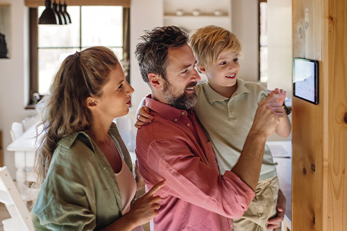 A family gathers around a television screen, exploring new construction homes in Mission, TX.
