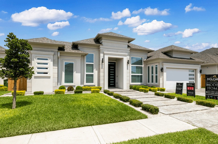 Modern single-story home with a landscaped front yard, featuring a stylish entrance and decorative shrubs.